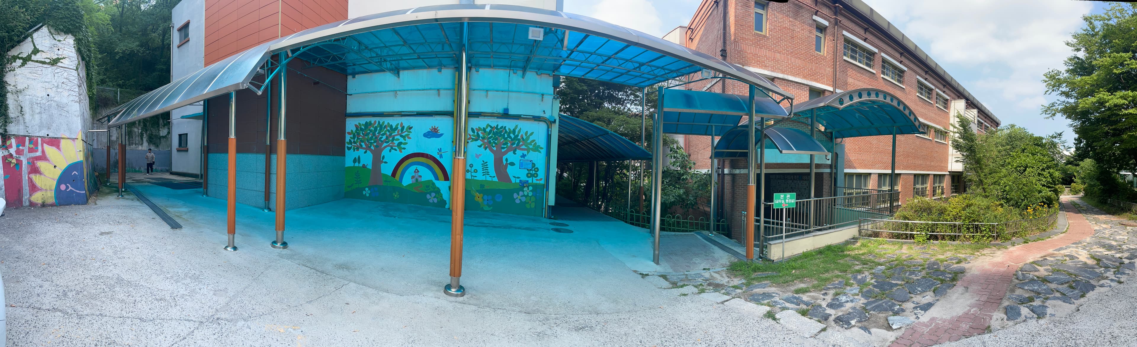 Main entrance with children's mural. The school to be replaced.