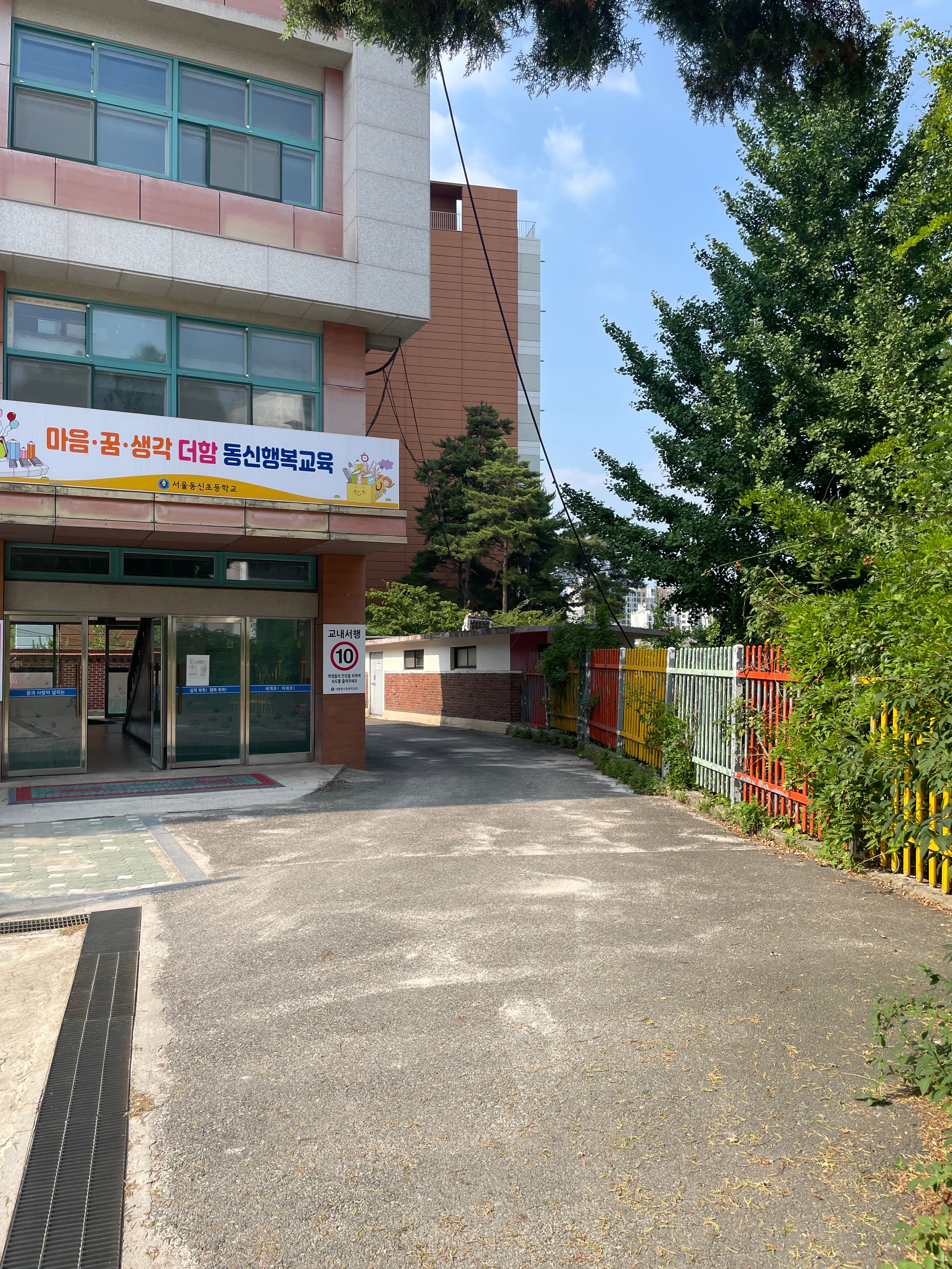 South facade and entry signage. Brick + concrete + polycarbonate canopy.