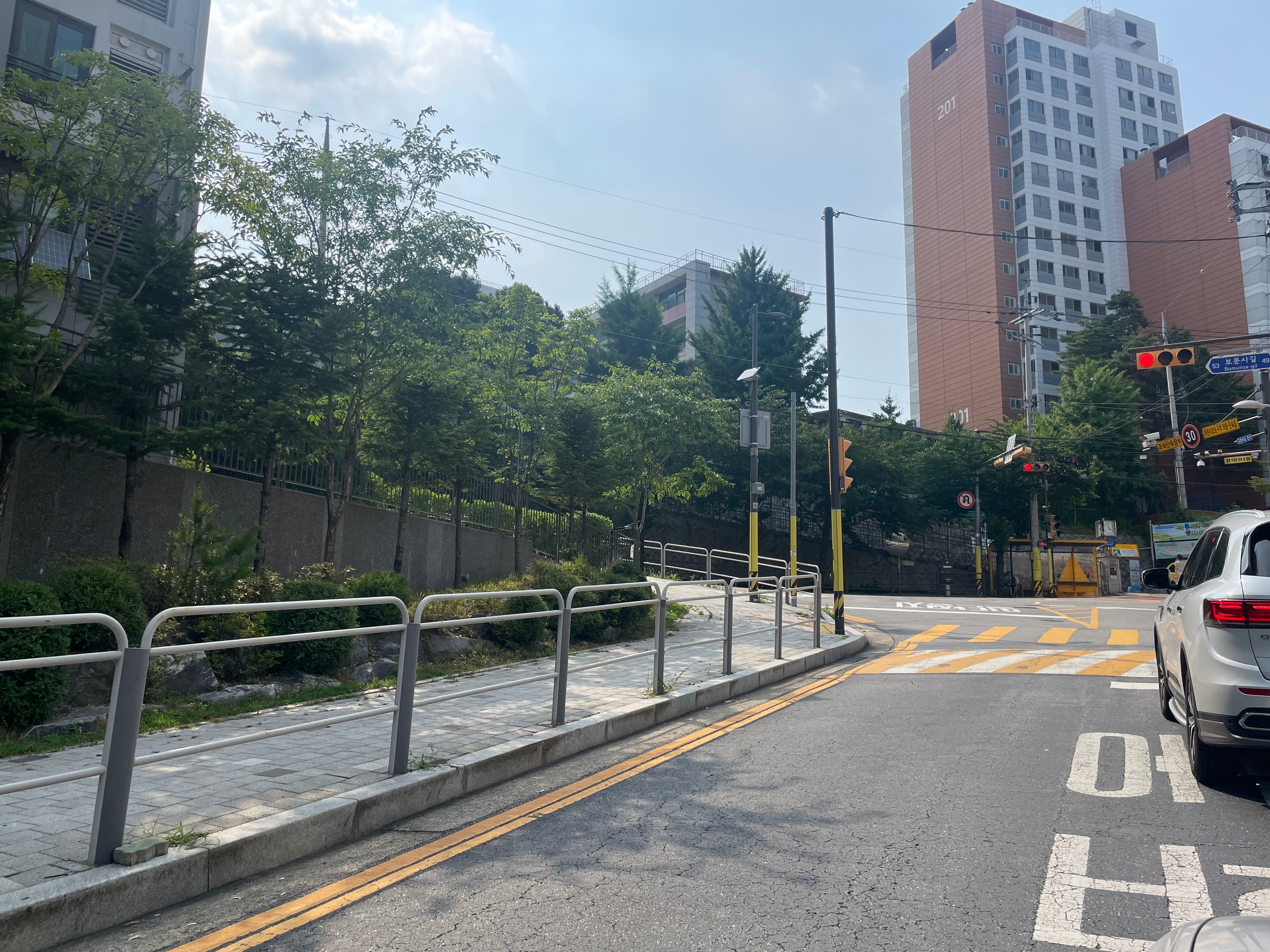Approach from Bomunsa-gil. Existing school behind apartment blocks.
