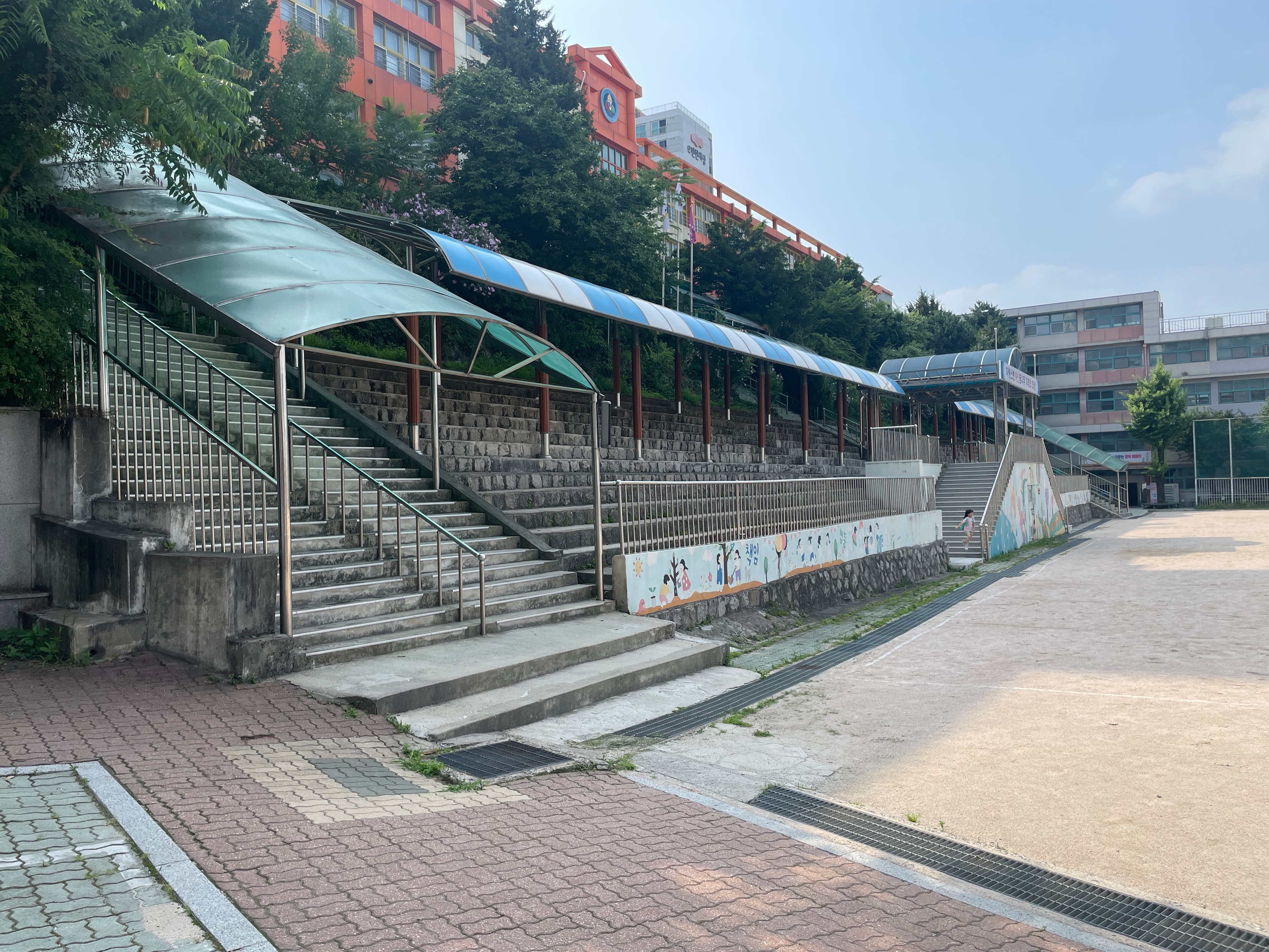 Schoolyard stairs and canopy. The slope that defines the section.